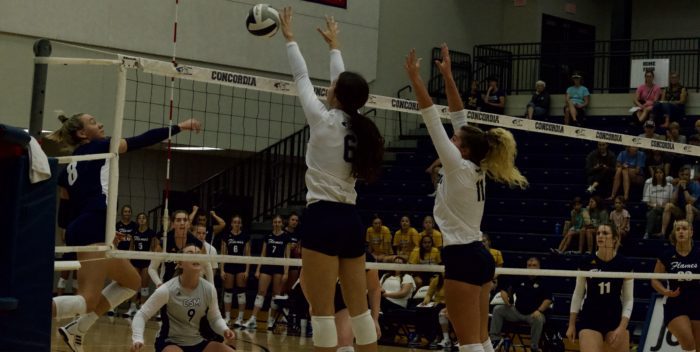 Freshman Ashley Keck and senior Camryn Opfer block a shot from College St. Mary (Image credit: Lexi Swenson)